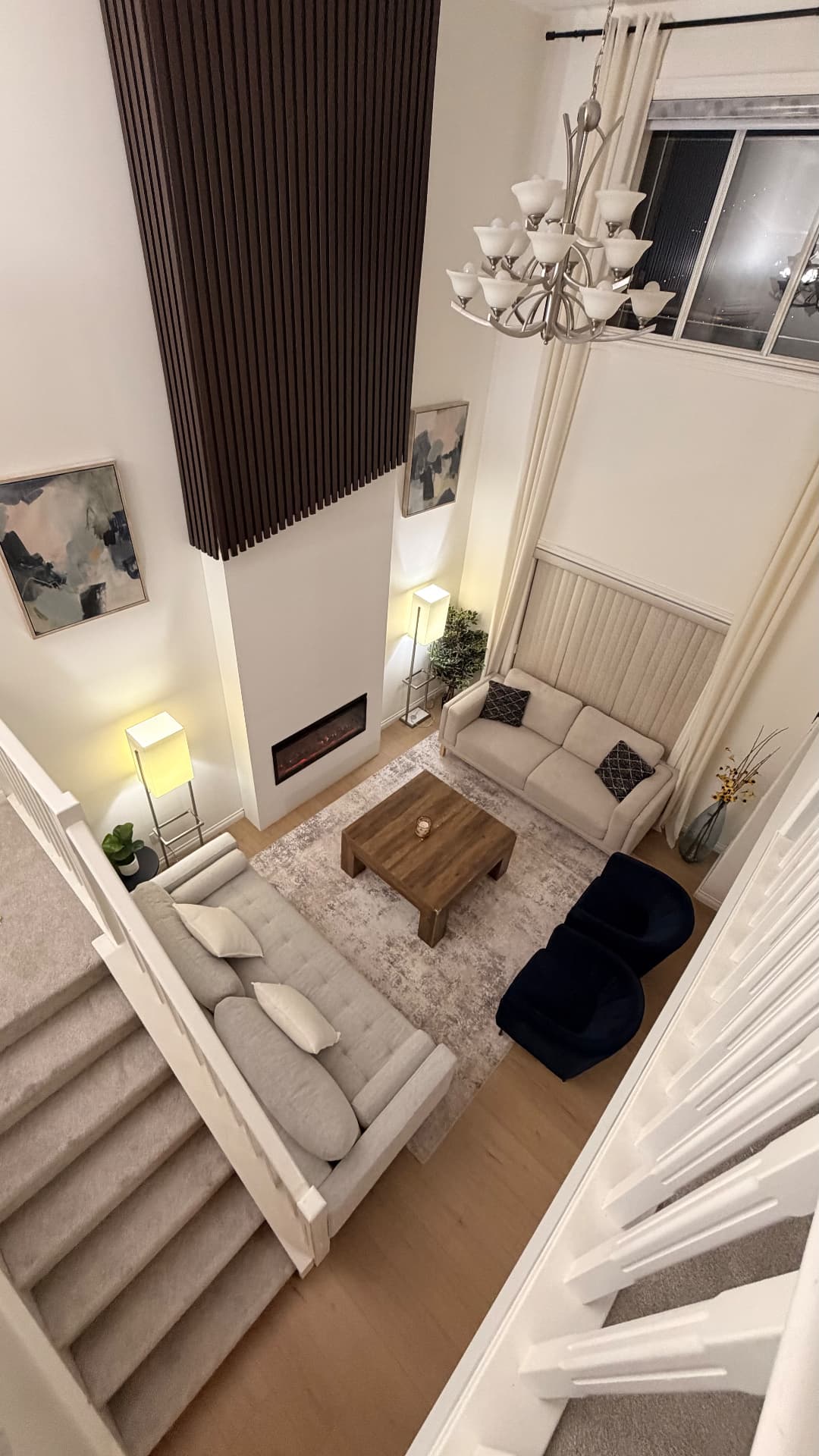 Two-storey Calgary living room photographed in the evening from the upper landing